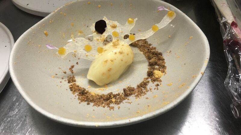 Cremoso de chocolate blanco con cristales de menta acompañado de unos puntos de gel de mango (nuestros menús semanales varían)