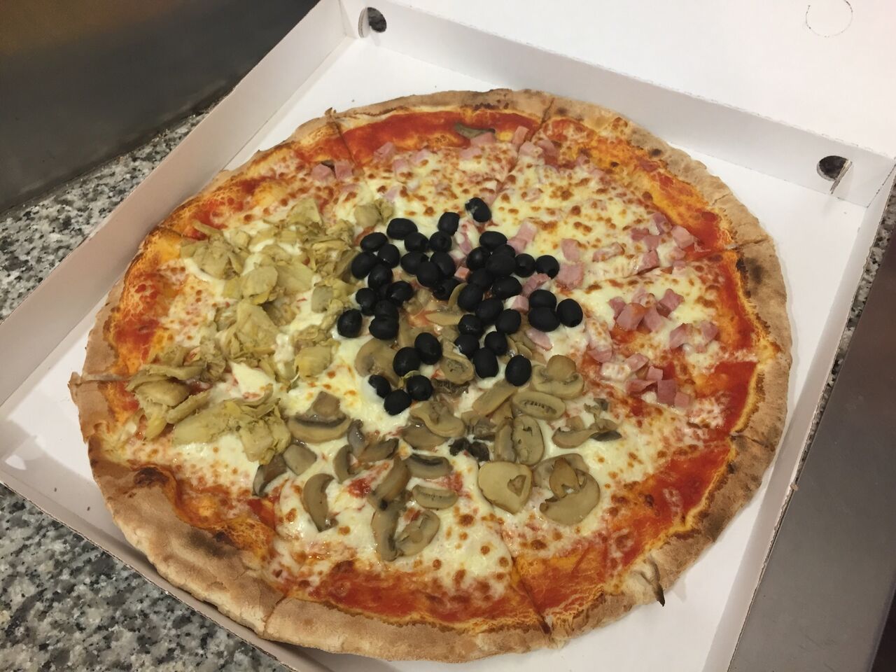 “4 stagioni” (pomodoro, mozzarella, prosciutto cotto, funghi, carciofi, olive nere. Formato famiglia)