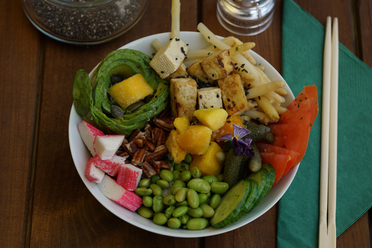 Let's Tofu : Poke Bowl met gebbaken tofu, avocado, edamame, komkommer, mango, surimi, tomaten, noten en saus