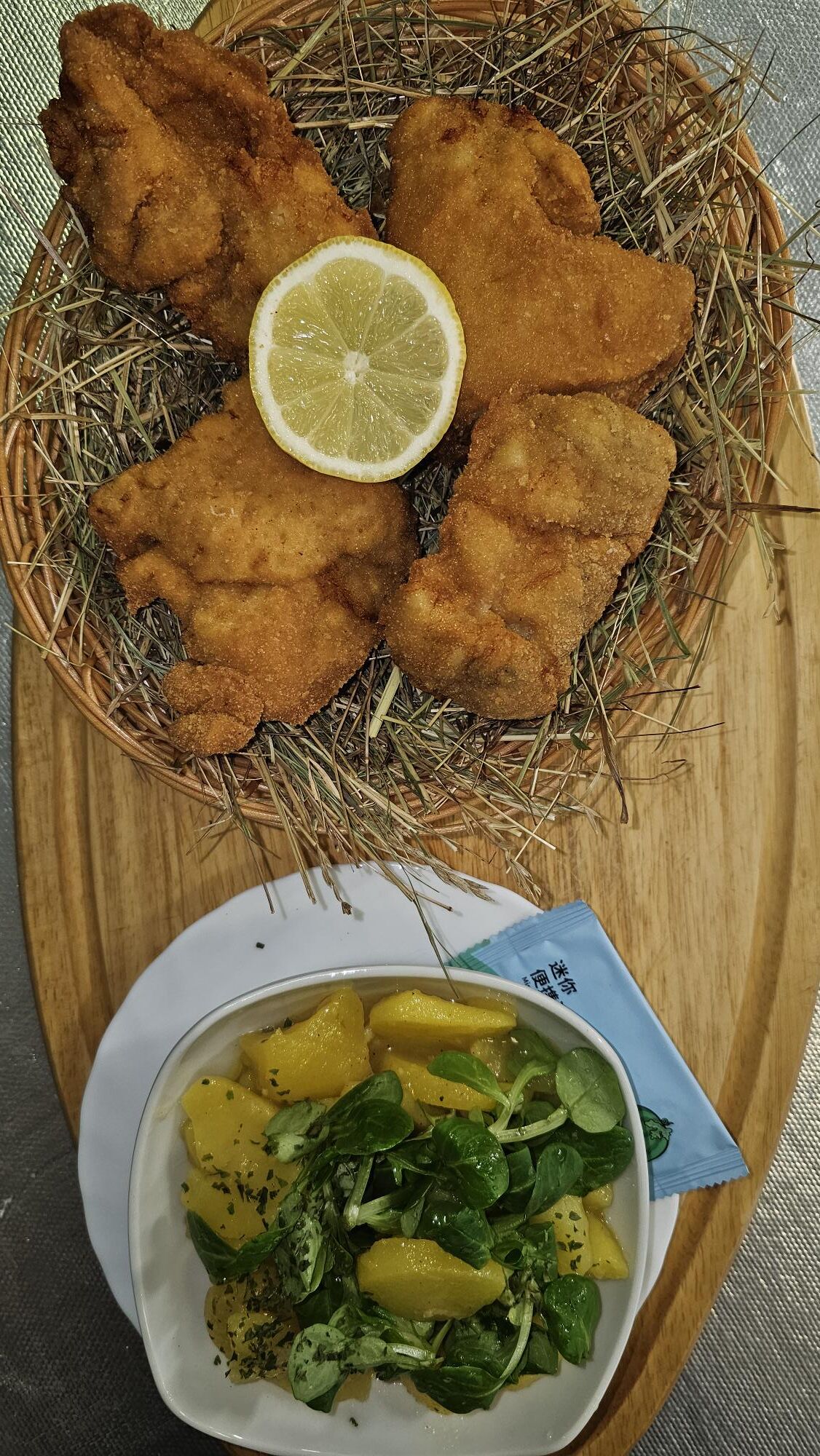 Ausgelöstes Backhendl im Strohkorb mit Vogerl-Kartoffelsalat