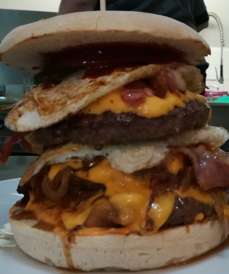 Giant Burger: 450gr. Rinderhack, 2 Spiegeleier, geschmorte Zwiebeln, Bacon und Käse