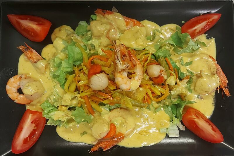 Flambée de noix de saint Jacques et crevettes, sauce coco curry au rhum.