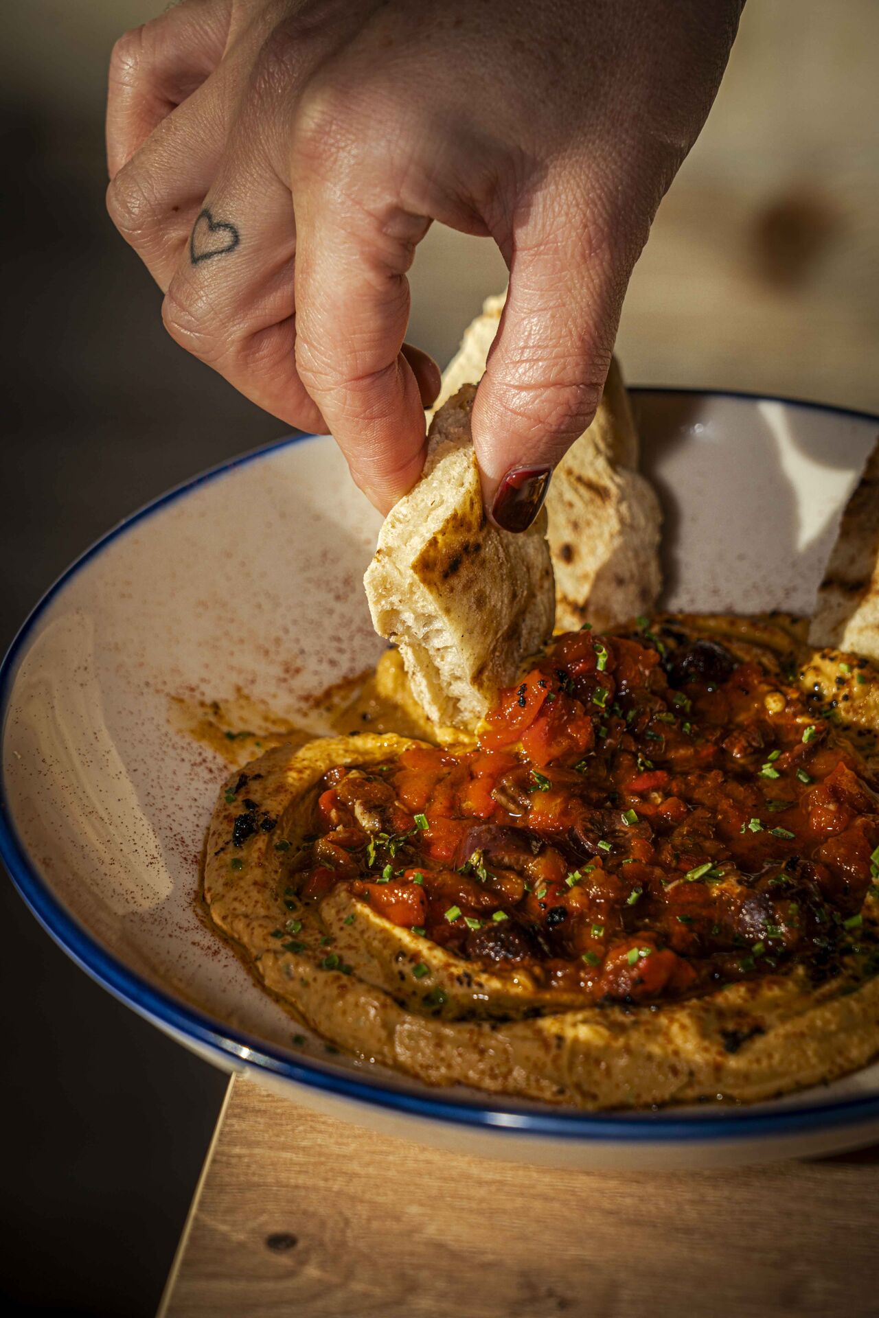 hummus con tomate seco, pimientos asados con nueces y pan pita