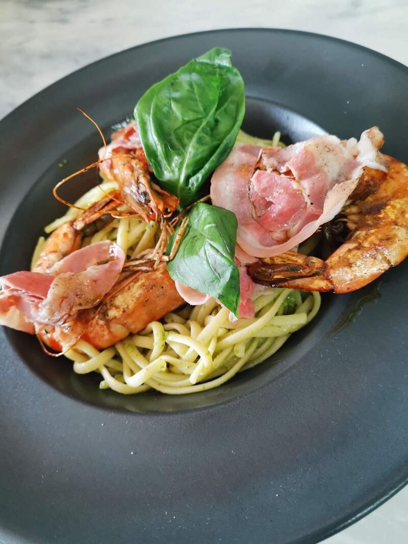 Linguines au pesto, gambas flambées et pancetta grillés.