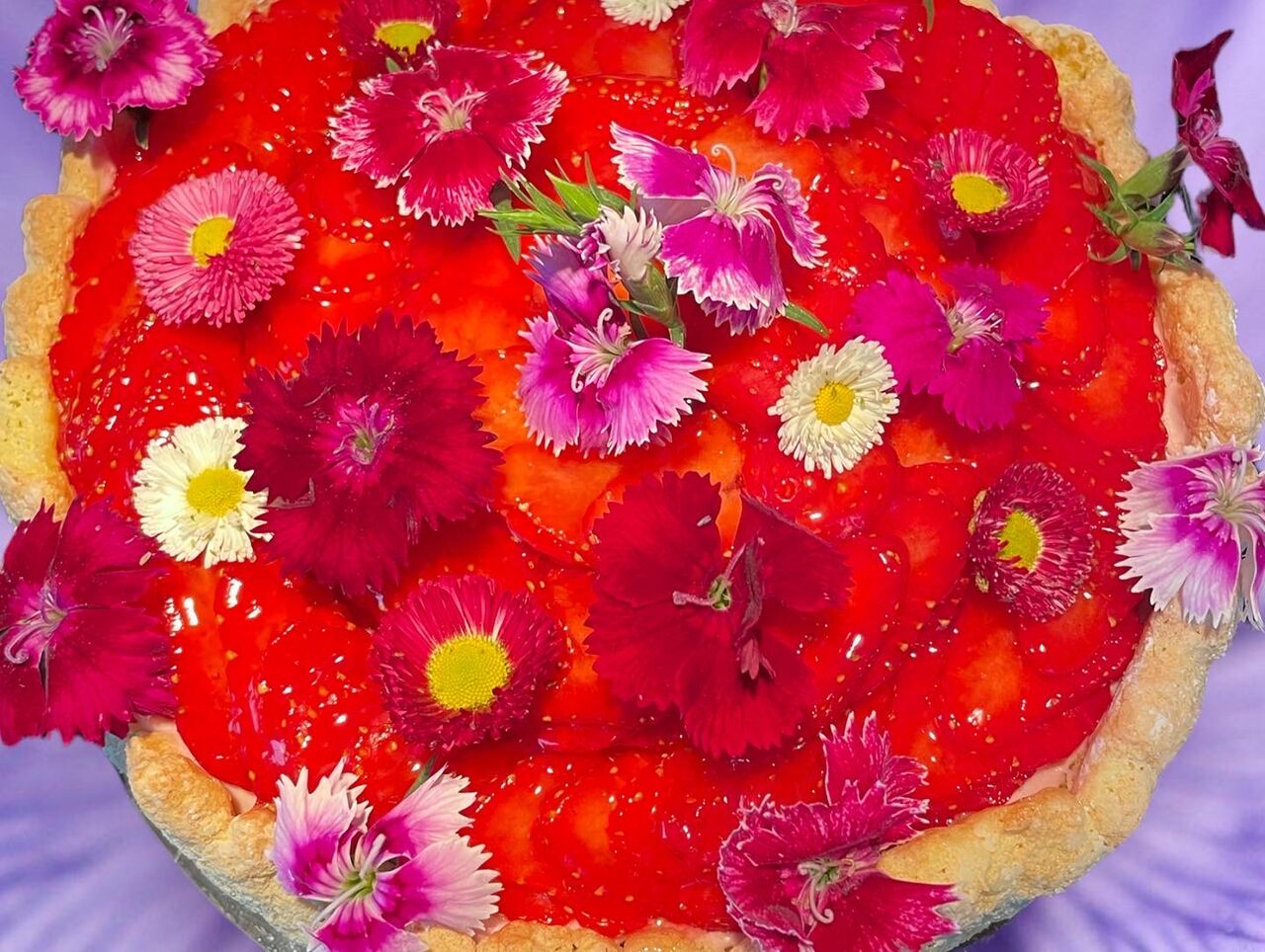 Charlotte aux fraises florales avec des fleurs comestibles .