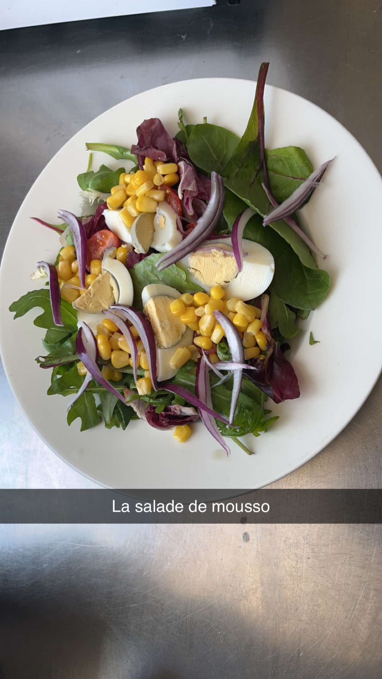 Salade de mousso. Salade verte tomates cerises oignons rouges, concombre maïs œuf dur et sauce vinaigrette à l'africaine