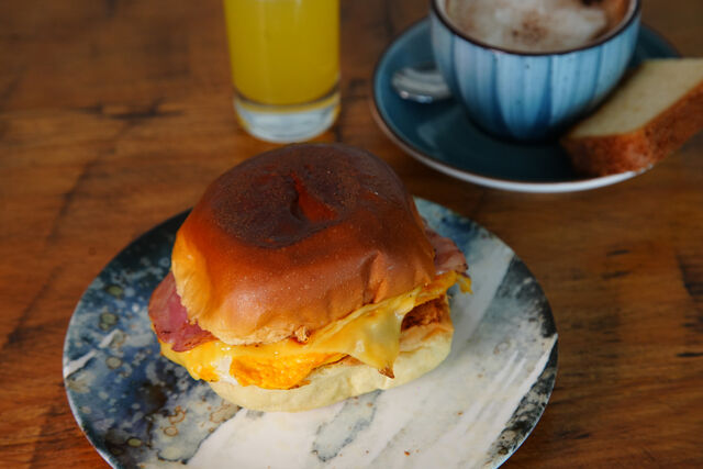 Brioche con huevo revuelto, bacon, queso y guacamole