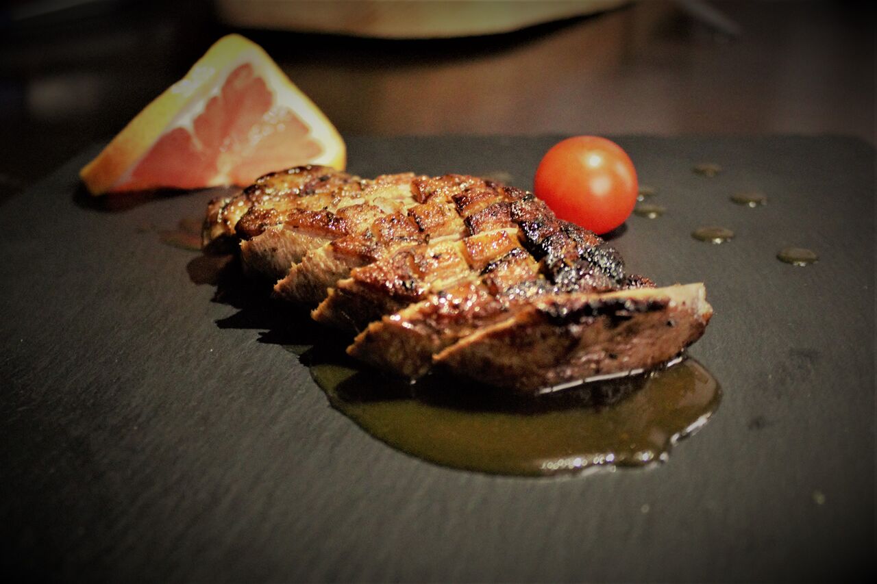 Duck breasts in an orange sauce.