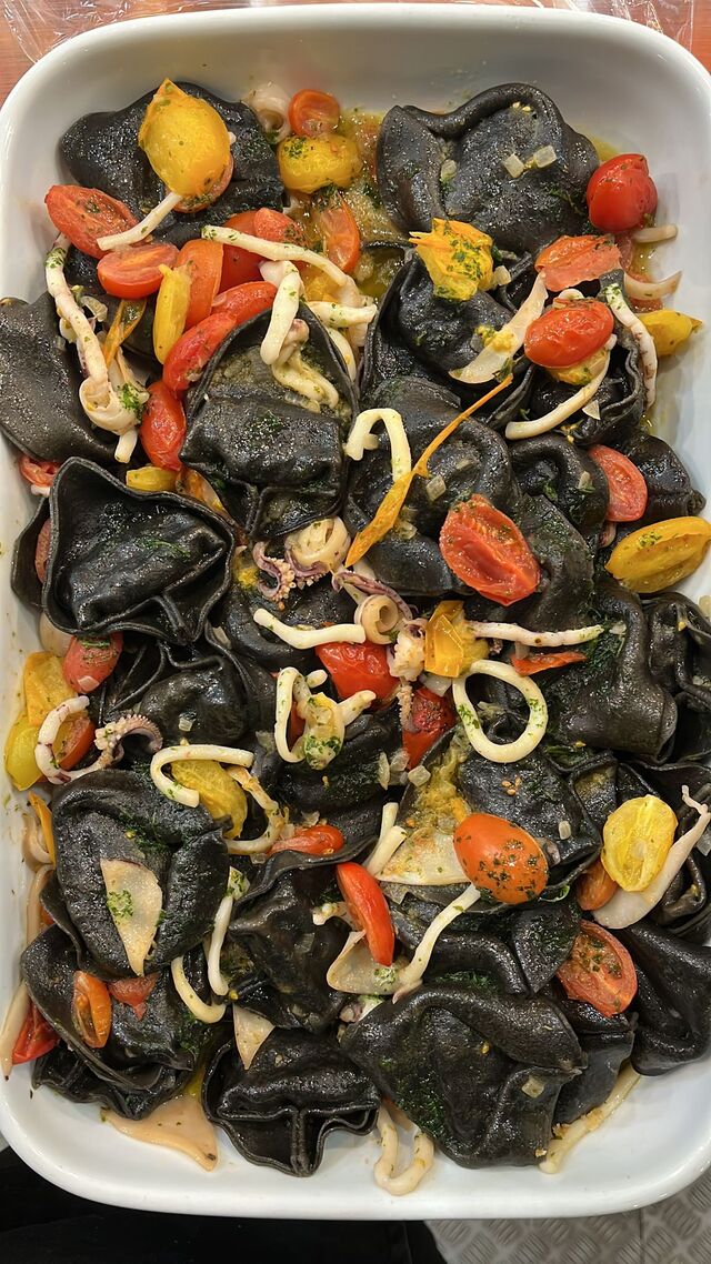 Tortelloni al nero di seppia con calamari e pomodorini