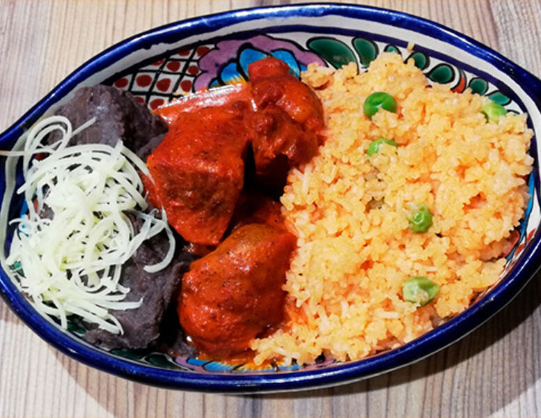 Cochinita Pibil: Ragoût de porc mariné dans l'Achiote légèrement pimenté. Accompagné de riz et d'une purée de haricots noirs