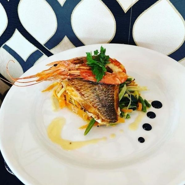 Filet de loup accompagné de légumes et gambas - Le BAY