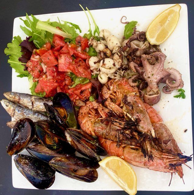 Assiette de la mer cuite au feu de bois et flambée au pastis avec des produits frais du jours