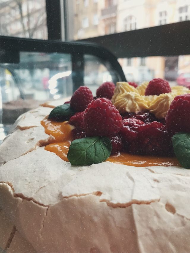 Tort bezowy z musem mango i malinami