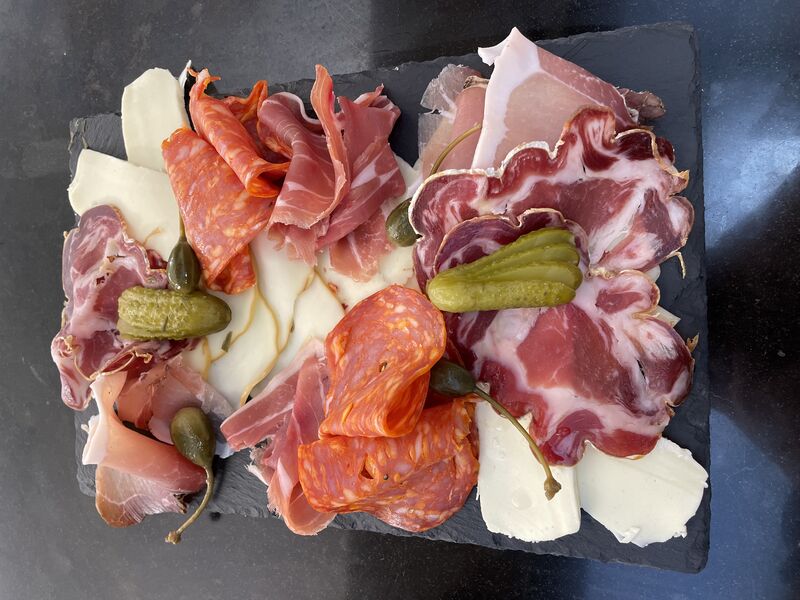 Planche apéritive à partager, charcuteries et fromages italiens.