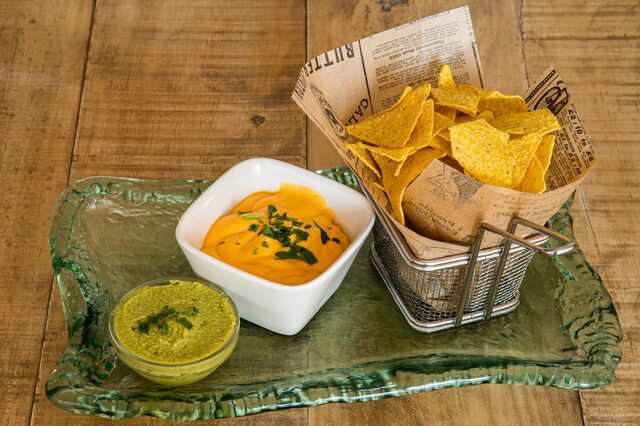 Nachos de maíz con salsas (queso cheddar con carne picada y guacamole).