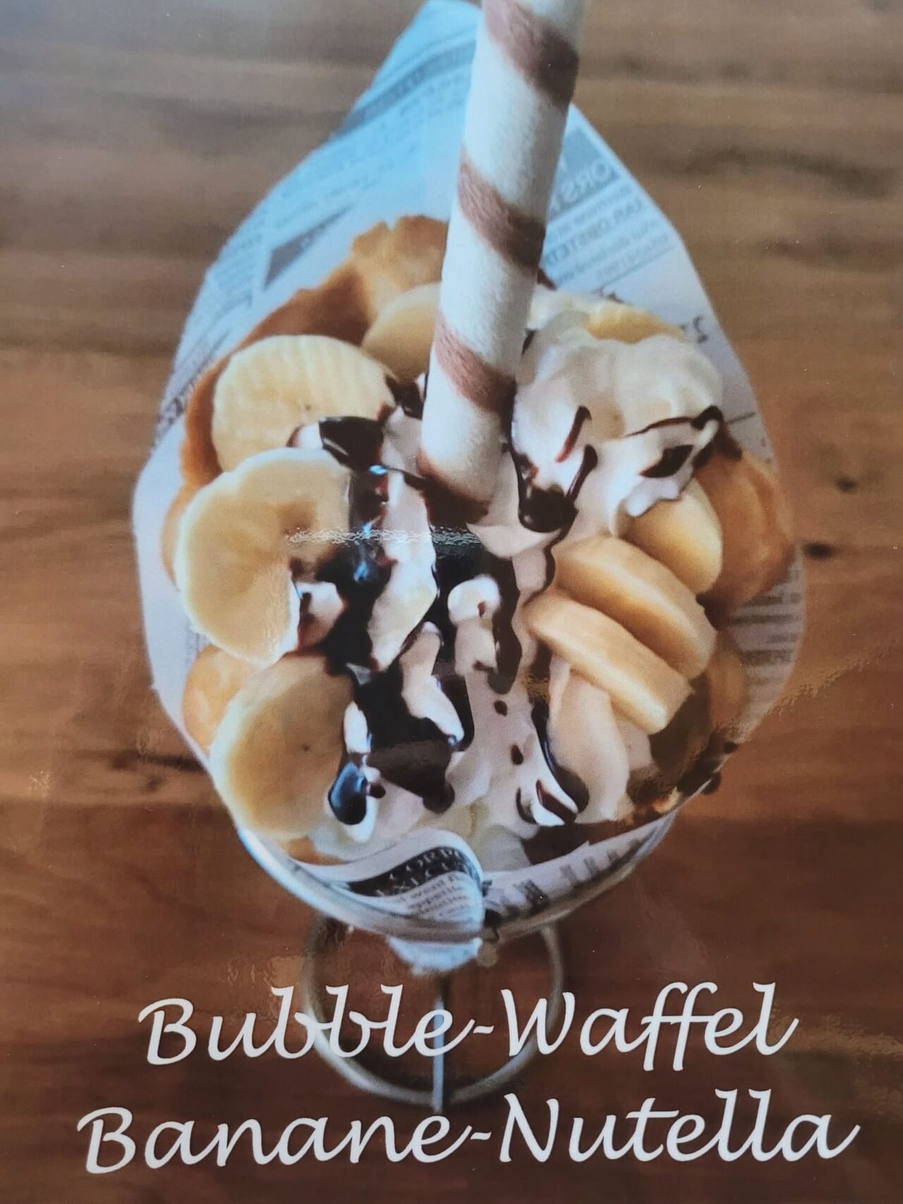 Warme Bubble-Waffel gefüllt mit 2 Kugeln Eis, frischen Bananen und einer leckeren Nutella-Soße.