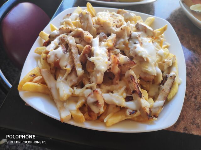 Ración de patatas con pollo a los 4 quesos y salsa cesar