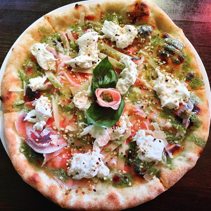 Pizza Pestosa mit Basilikumpesto, Mozzarella, Bauchspeck, Mandeln, Burrata und Mandeln