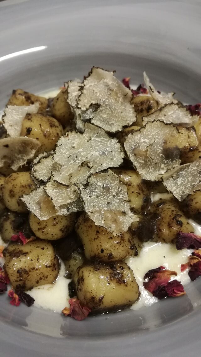Gnocchi con tartufo serviti su fonduta di taleggio