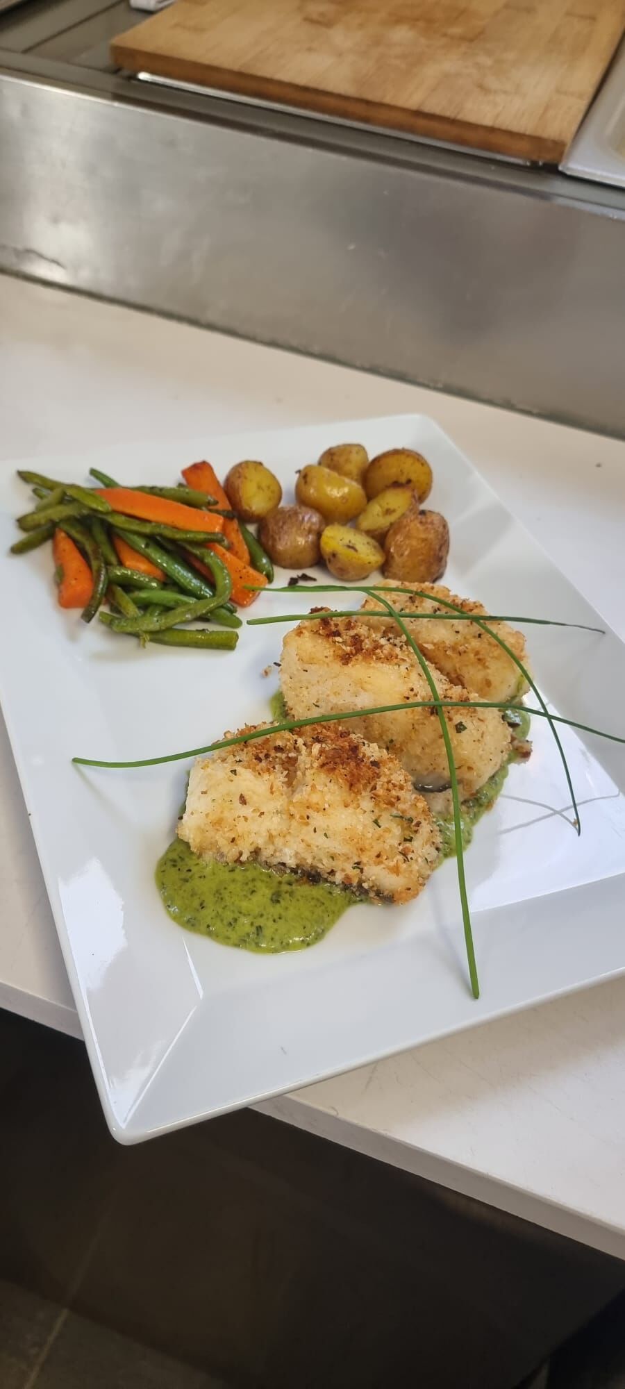 Skreifilet in crosta aromatizzata alle Erbe su salsa verde 