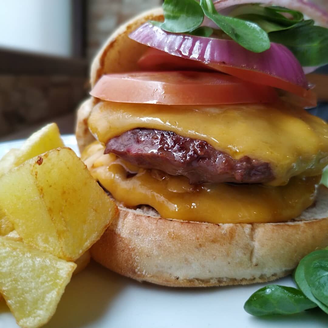 Hamburguesa la Giralda. (Pan rústico, carne de buey trufada, queso cheddar, tomate canonigos y salsa argentina. 