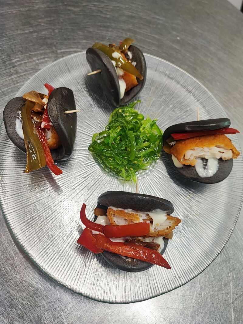 Bao negro relleno verduras y merluza rebozada 