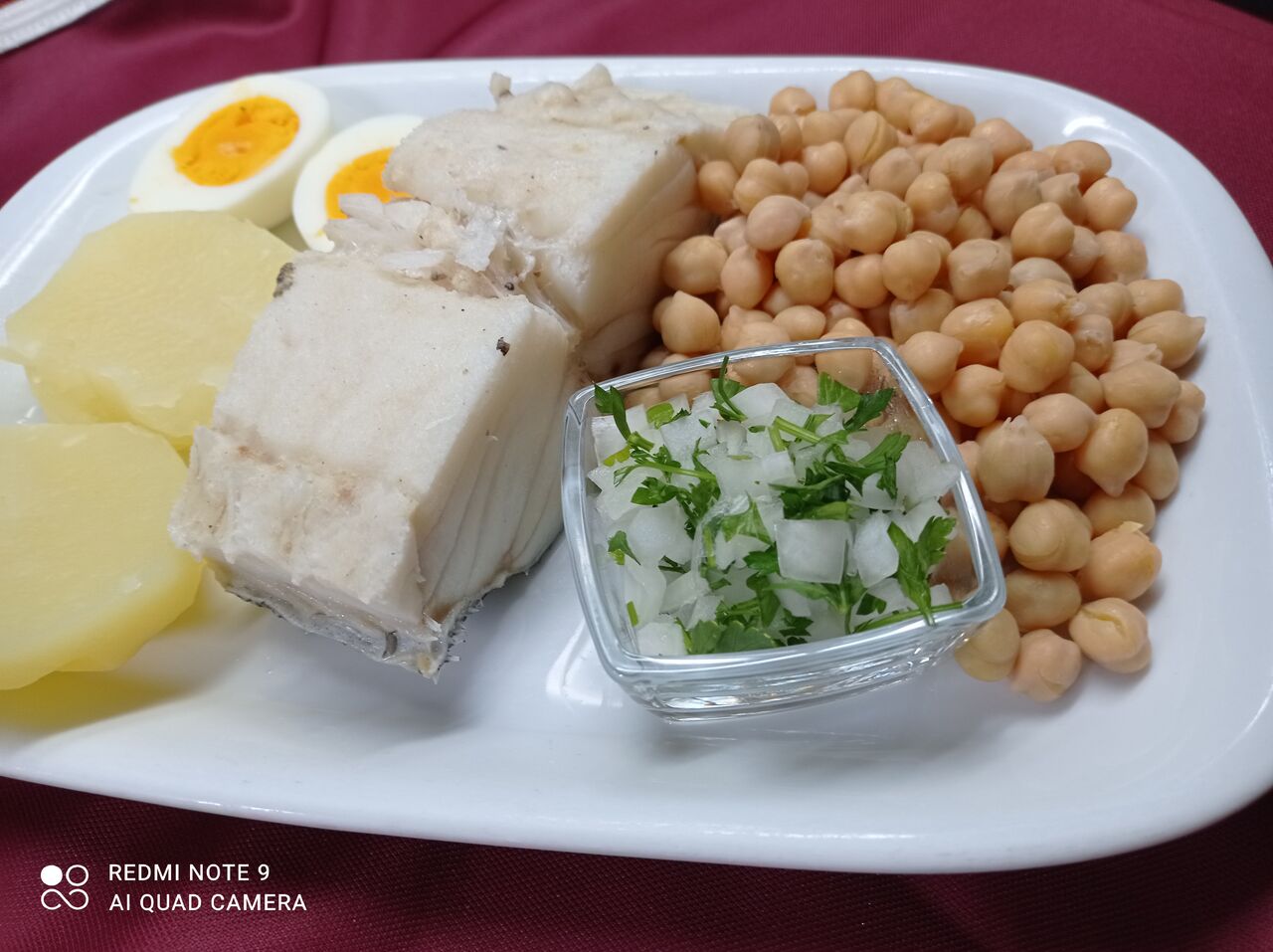 Lombo de bacalhau cozido com ovo cozido, batata cozida e grão.