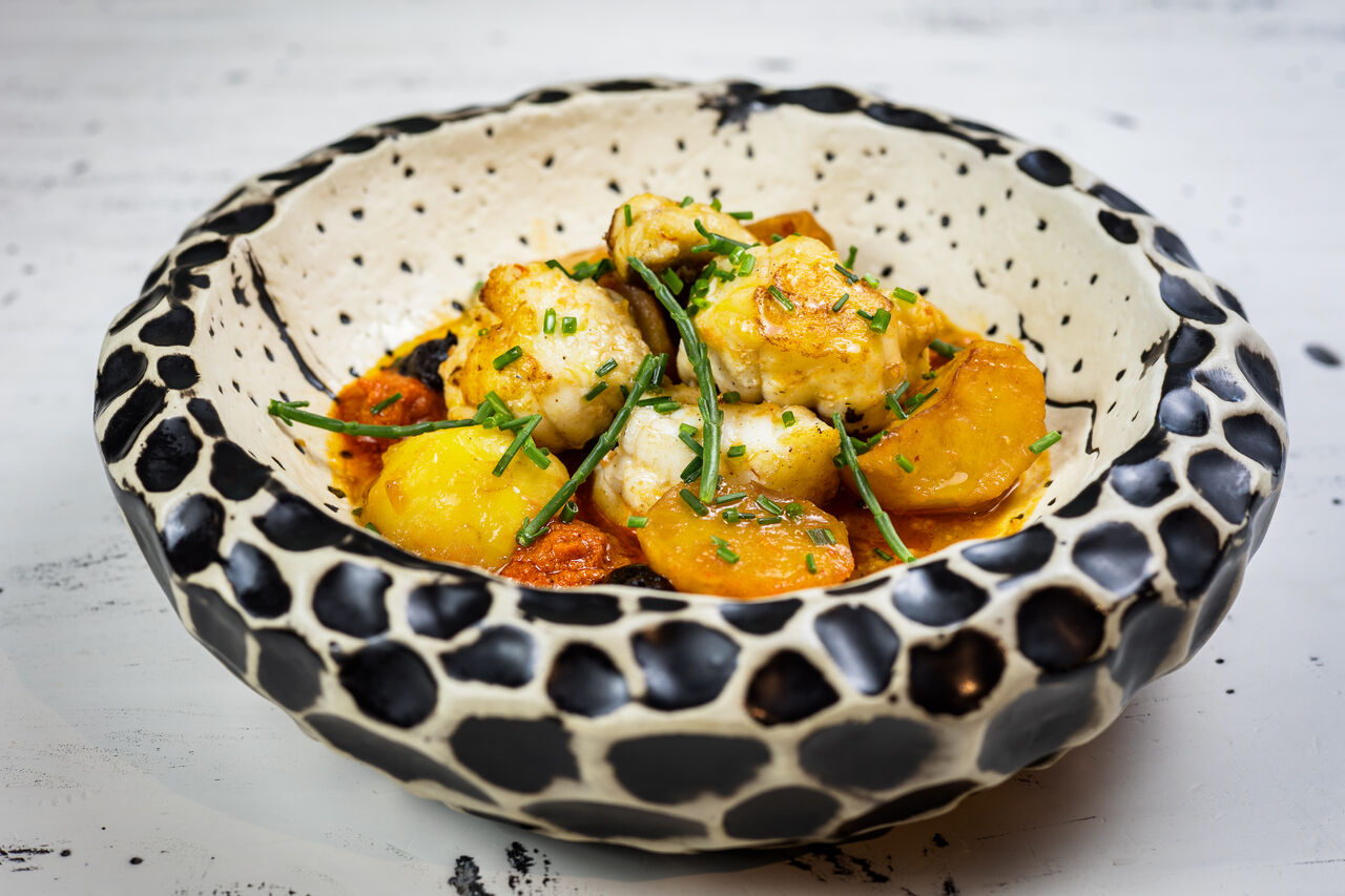 🐟 Rape con patatas jazzy guisadas 🥔, romesco, ajo negro asado y polvo de picada.