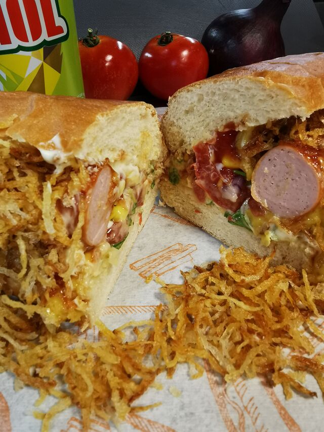 Cachorro quente : pain artisanal, saucisse knack, salade, tomates, oignons, maïs et pommes pailles maison
