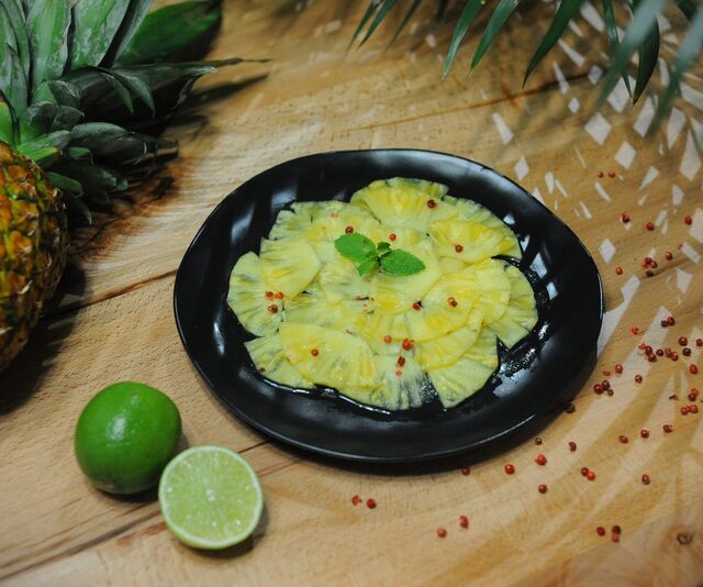 Carpaccio d'ananas, sirop de gingembre-citron vert et baies roses