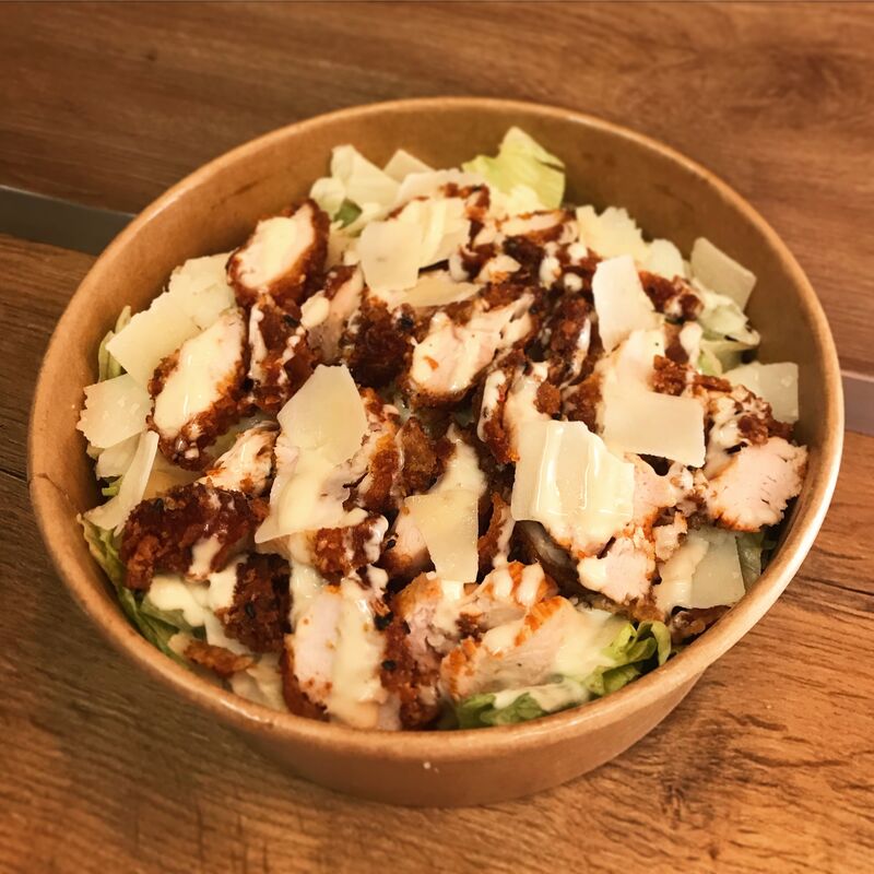 La Salade Cesar! Composée de Parmesan AOP, de Sauce César, d'émincé de poulet croustillant et évidement de Salade iceberg