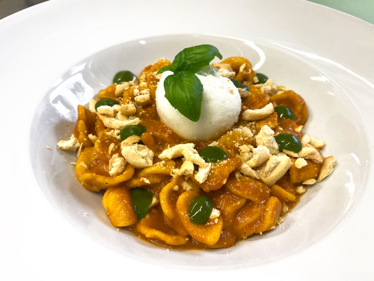 Orecchiette con salsa di pomodoro al forno, burratina, crumble di tarallo pugliese ed emulsione di basilico