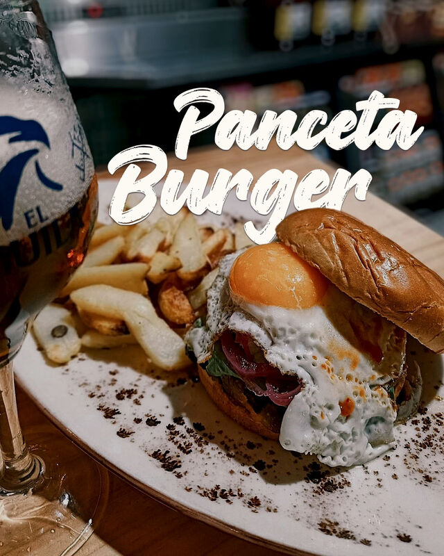 Nuestra panceta, queso cheddar, cebolla encurtida, lechuga, huevo frito y salsa