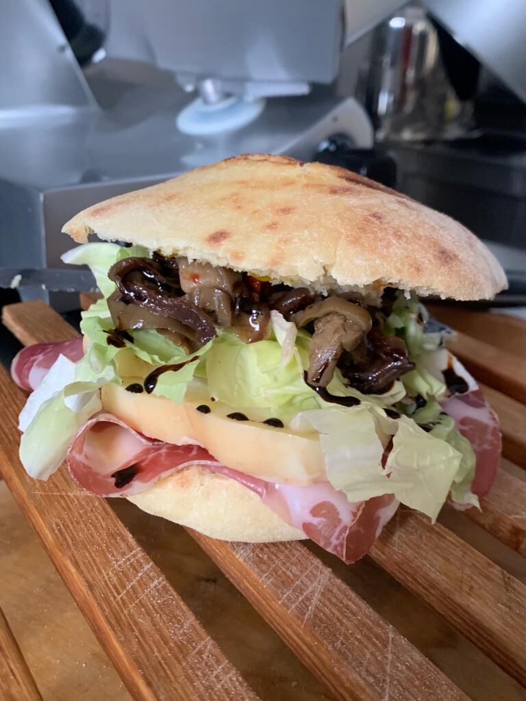 Puccia con capocollo, caciocavallo, insalata cicoria, cipolla rossa al mosto d’uva, pomodori essiccati e olio evo