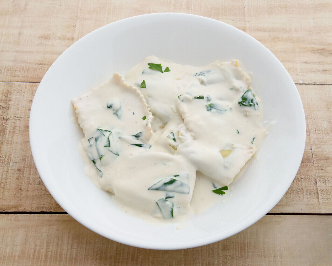 Raviolis rellenos de queso parmesano y espinacas