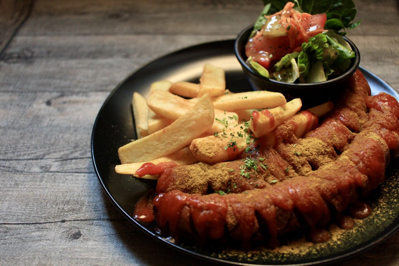 A Berlin Classic - Currywurst with fries and side salad with fig dressing.