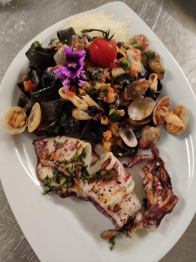 Tagliatelles à l'encre de seiche fait maison aux fruits de mer et calamars grillès