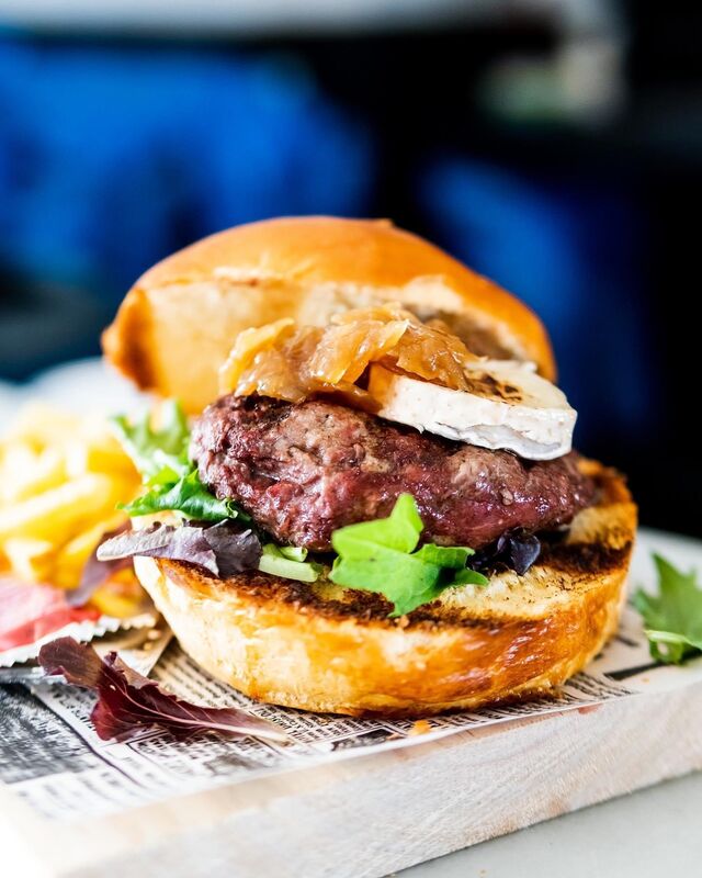 Hamburguesa de retinto con queso de cabra y cebolla caramelizada.