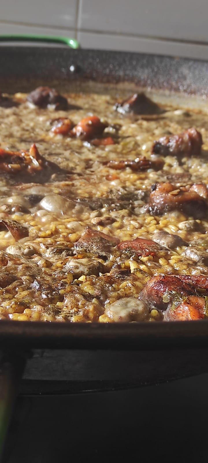 Paella valenciana con alcachofas y habas de temporada.