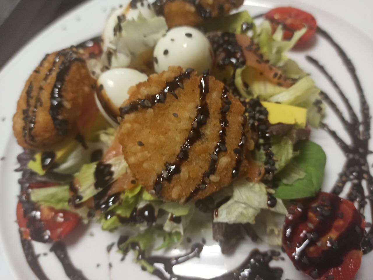 Ensalada Nido con camembert en tempura, huevos de codorniz, aguacate y salsa de iogurt