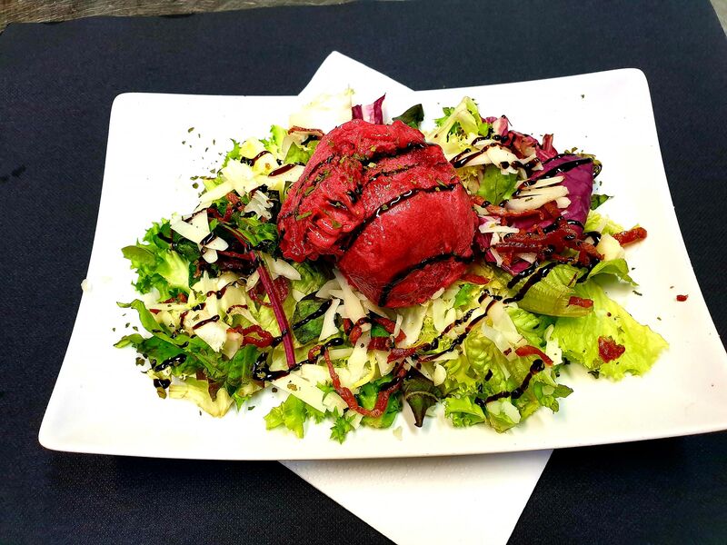 Ensalada con helado de frutos del bosque, queso manchego y lascas de jamón ibérico.