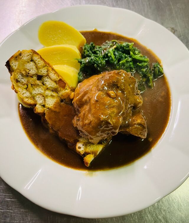 Jehněčí kolínko se špenátem, bramborovým knedlíkem a nádivkou 