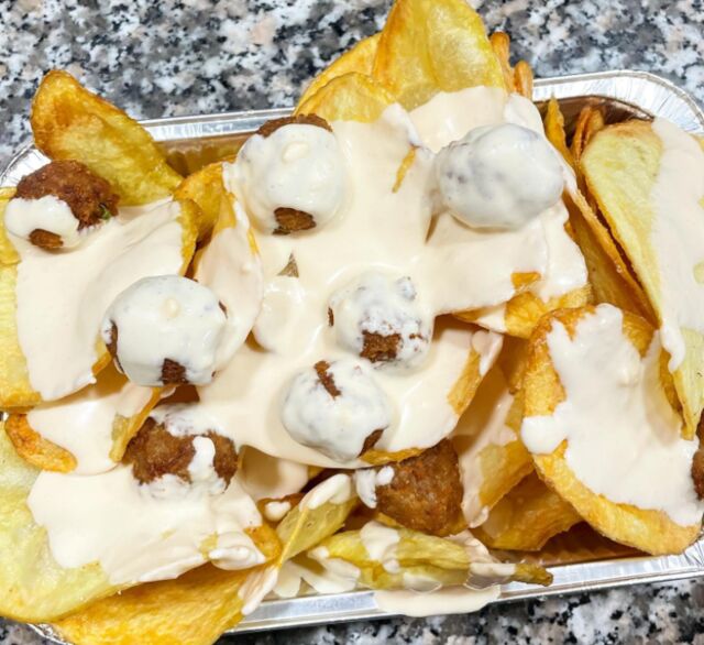 Patatine chips e polpettine fritte ricoperti di fonduta di formaggio