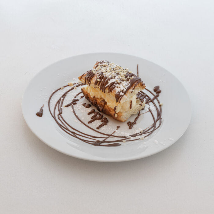 Alejandrito, ojaldre crujiente horneado, relleno de crema pastelera preparada en duetto y cubierto con chocolate.