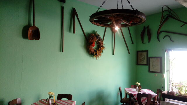 Gastraum mit alten landwirtschaftlichen Geräten