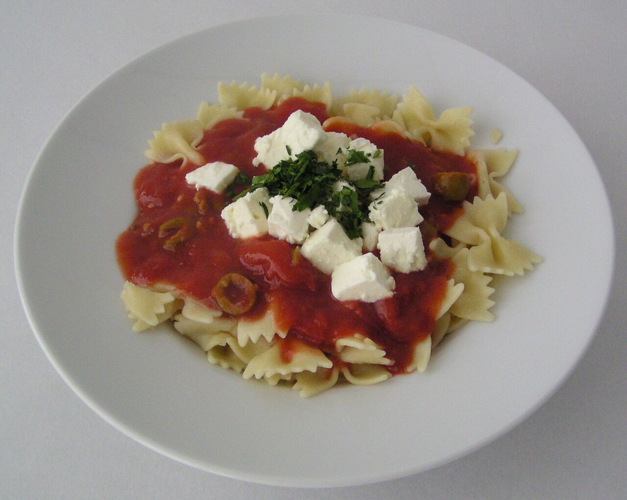 Farfalle mit Tomaten-/Olivensauce und Schafskäse