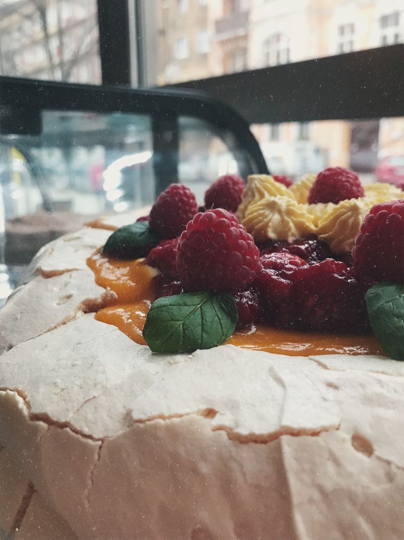 Tort bezowy z musem mango i malinami