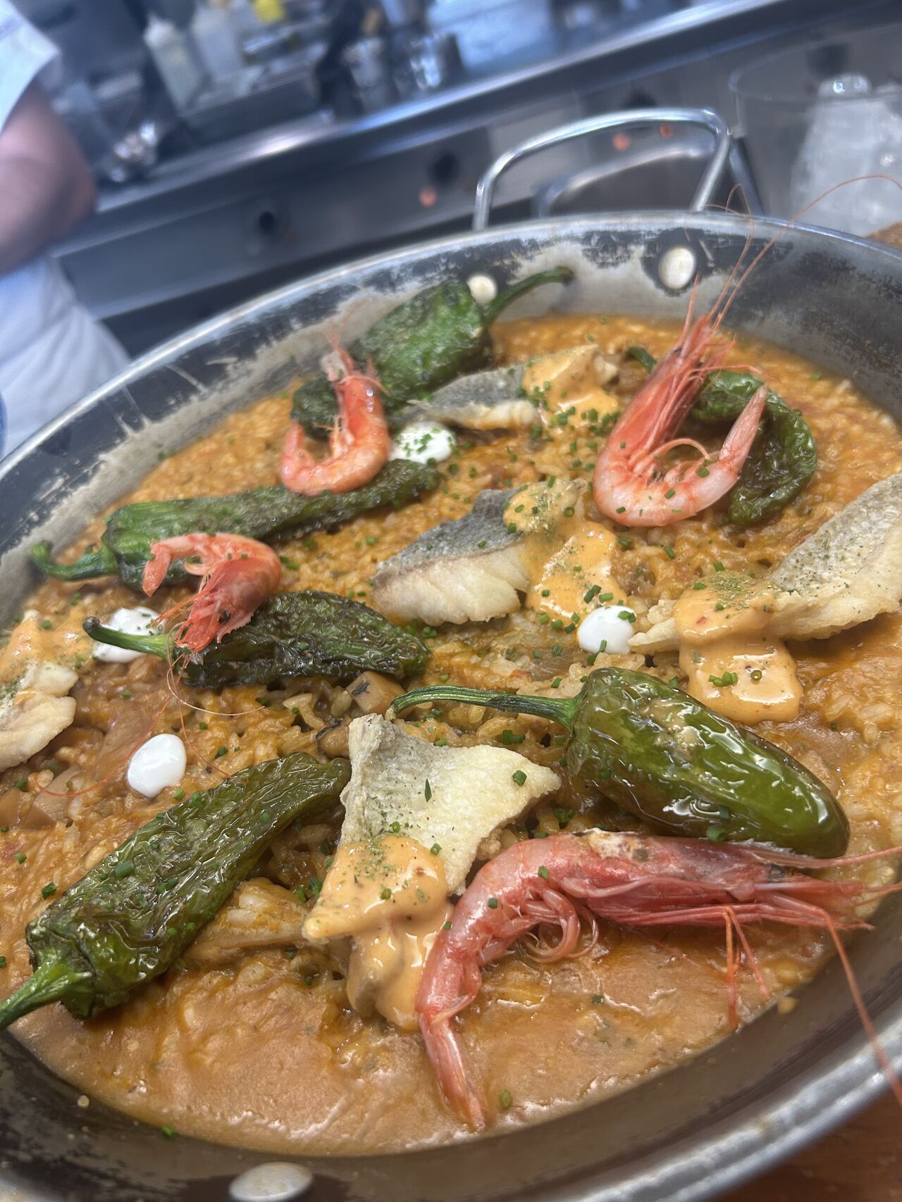 paella di riso bomba , ragù di seppie , orate e piccoli gamberi , friggitelli e brodo di pesce da zuppa 