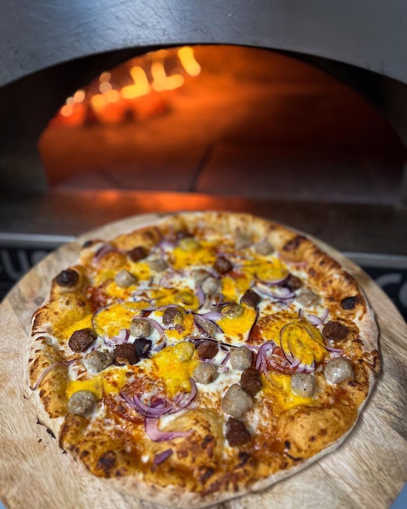 Pizza qui sort du four à bois