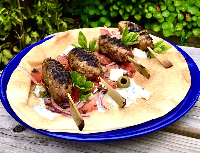 Libanees platbrood met gegrilde kebabspiesjes, tzatziki en een salade van watermeloen, feta, olijven en munt